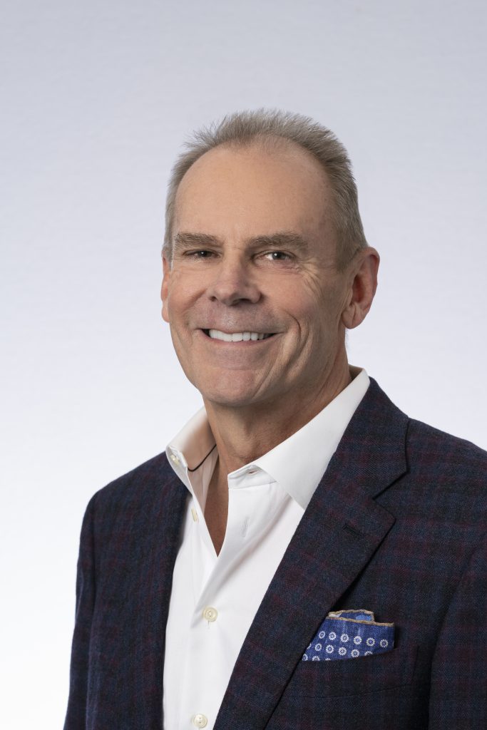 Charles Knight, in a navy and oxblood tweed jacket over an open white collar.